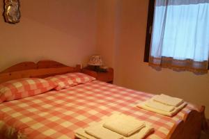 a bedroom with two beds with towels on them at MirarMonti nel cuore di Pozza con i tuoi animali in Pozza di Fassa