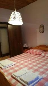 een slaapkamer met een bed met een geruite deken bij MirarMonti nel cuore di Pozza con i tuoi animali in Pozza di Fassa