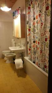 a bathroom with a toilet and a shower curtain at MirarMonti nel cuore di Pozza con i tuoi animali in Pozza di Fassa
