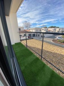 einen Blick vom Balkon eines Hauses mit grünem Gras in der Unterkunft Logement Confort 2 Chambres / Séjour-cuisine proche de Montpellier in Saint-Aunès