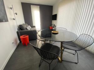 ein Wohnzimmer mit Tisch und Stühlen und einer Couch in der Unterkunft Logement Confort 2 Chambres / Séjour-cuisine proche de Montpellier in Saint-Aunès