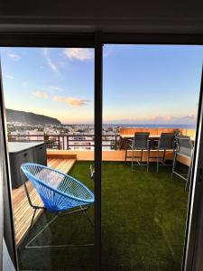une chaise bleue sur un balcon avec vue dans l'établissement Sea View & More…, à Saint-Denis