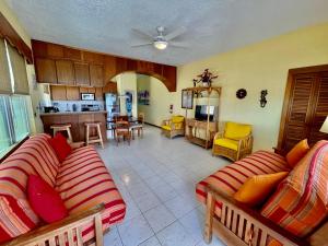 a living room with two couches and a kitchen at Belizian Reef Suites in San Pedro