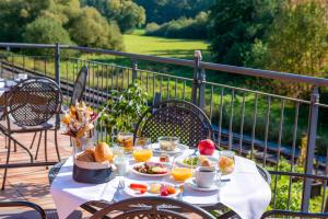 una mesa con comida y fruta en el balcón en BEHLs Genusshotel im Brennhaus en Blankenbach