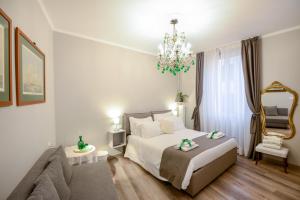 a bedroom with a bed and a couch and a chandelier at Il Genovino in Genoa