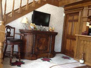 ein Wohnzimmer mit einem TV und einem Stuhl in der Unterkunft Stratford Inn Tyler in Tyler