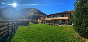 une maison dans un champ à côté d'une clôture dans l'établissement Retreat from Cluj, à Mărişel