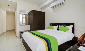 a bedroom with a large bed with green and white pillows at Treebo Kamron Regency Sector 80 in Mohali +39 photos