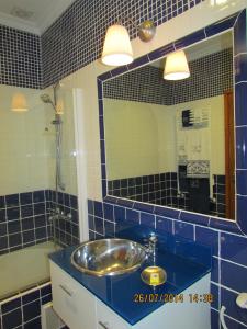 a blue tiled bathroom with a sink and a mirror at Quinta de Coalhos TH in Abrantes