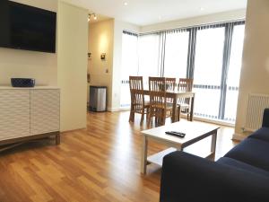 a living room with a couch and a table and chairs at Western Gate, Executive Central Apartments in Basingstoke
