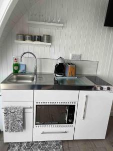 a kitchen with a sink and a microwave at Orkney Lux Lodges - Brinkies Retreat in Stromness