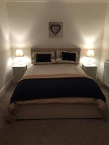 a bedroom with a large bed with two night stands at Craigewan Cottage Seatown Cullen in Cullen