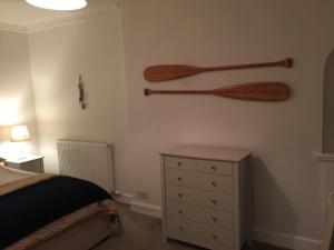 a bedroom with a bed and two wooden oars on the wall at Craigewan Cottage Seatown Cullen in Cullen