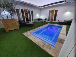 una piscina en medio de un patio con césped verde en PENTHOUSE Jan Thiel Curacao, en Willemstad