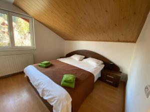 ein Schlafzimmer mit einem Bett mit grünen Handtüchern darauf in der Unterkunft VILA MARIS BUSTENI in Buşteni