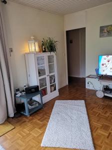 an empty living room with a table and a tv at Haus am Hennesee in Meschede