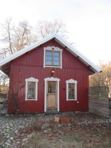 un granero rojo con una puerta y dos ventanas en Beautiful apartment close to lake Mälaren, en Södertälje