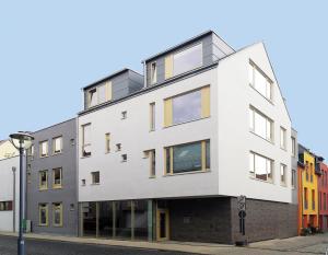 un edificio blanco en una calle con edificios coloridos en Eckhof Domizil en Gotha