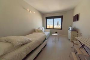 sypialnia z 2 łóżkami, kanapą i oknem w obiekcie RentalSevilla Resitur II w Sewilli