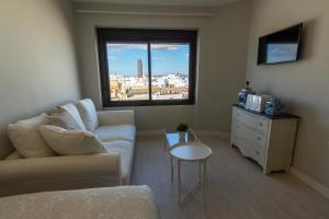 salon z kanapą, stołem i oknem w obiekcie RentalSevilla Resitur II w Sewilli