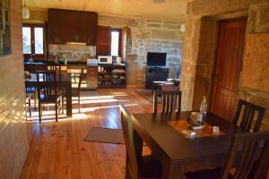 eine Küche und ein Wohnzimmer mit Tisch und Stühlen in der Unterkunft Casa Florestal, na Branda da Bouça dos Homens in Gavieira