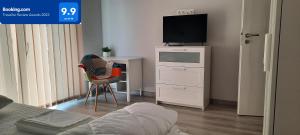 a bedroom with a bed and a television on a dresser at Baman Apartment in Cluj-Napoca
