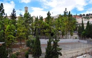 un parque con árboles y una pista de tenis en Amwaj Apartments, en Nazaret