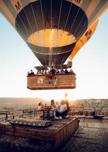 a hot air balloon with people riding on the deck at Sultan Cave Suites in Göreme