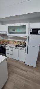 a kitchen with white cabinets and a sink at Aparahik in Ushuaia