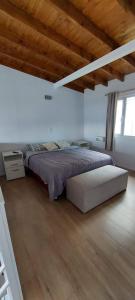 a bedroom with a large bed with a wooden ceiling at Aparahik in Ushuaia