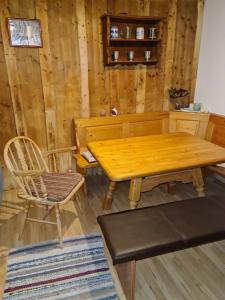 a wooden table and a chair in a room at Ferienwohnung Haus Oberlarchhof in Bayrischzell