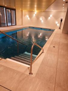 a indoor swimming pool with stairs in a building at DOMITYS - Les Papillons d'Azur in Saint-Quentin