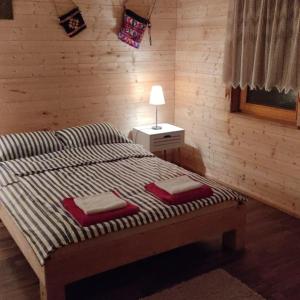 a bedroom with a bed with two towels on it at WOODEN HOUSE near the River Kupa in Kamanje
