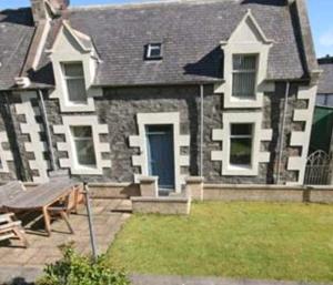 una grande casa con un tavolo da picnic di fronte di Craigewan Cottage Seatown Cullen a Cullen