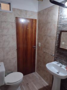 a bathroom with a toilet and a sink and a shower at casa particular adrogue entrada individual in José Mármol +3 photos