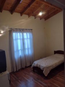 a bedroom with a bed and a large window at casa particular adrogue entrada individual in José Mármol