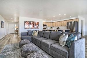 a living room with a gray couch and a kitchen at Luxe Family Condo with Mtn View and Resort Perks! in St. George