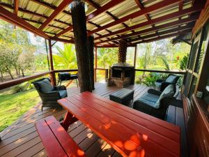 una terraza de madera con banco y chimenea en Kane Villas - Mountain Pine Ridge en San Ignacio