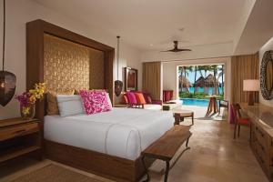 Un dormitorio con una cama grande y una sala de estar. en Secrets Akumal Riviera Maya - Adults Only, en Akumal
