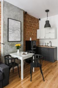 a kitchen and dining room with a white table and chairs at Soft Loft 1 Apartment in Toruń