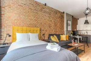 a bedroom with a large bed and a brick wall at Soft Loft 1 Apartment in Toruń