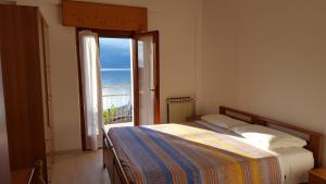 Schlafzimmer mit einem Bett und Meerblick in der Unterkunft casa Leo in Magugnano-Marniga