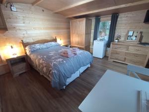 1 dormitorio con 1 cama y pared de madera en Cosy Cabin, en Stock