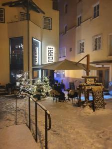 patio ze stołem i parasolem przed budynkiem w obiekcie Appartement Pension Bäckenhäusl FERIENWOHNUNGEN Chalets Hütten Komfortzimmer w mieście Uttendorf