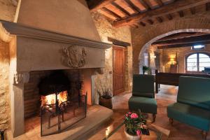 un salon avec une cheminée et un piano dans l'établissement Borgo Il Poeta, à Monte Castelli