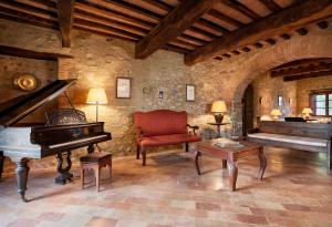 een woonkamer met een piano en een stoel bij Borgo Il Poeta in Monte Castelli