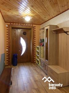 Cette chambre est dotée d'une porte en bois et de parquet. dans l'établissement ЗОЛОТА РИБКА, à Slavsko