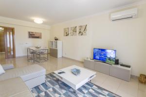 Una sala de estar con un sofá y un televisor. en Millennium Plaza, en Vilamoura