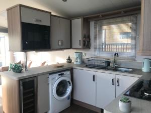 a kitchen with a washing machine and a sink at Number 47 @ Lilliardsedge in Jedburgh