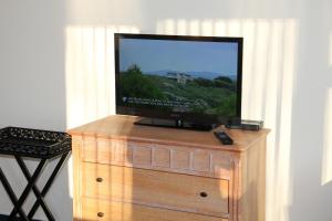 a flat screen tv sitting on a wooden dresser at Fewo-Suite mit Seeblick in Ascheberg
